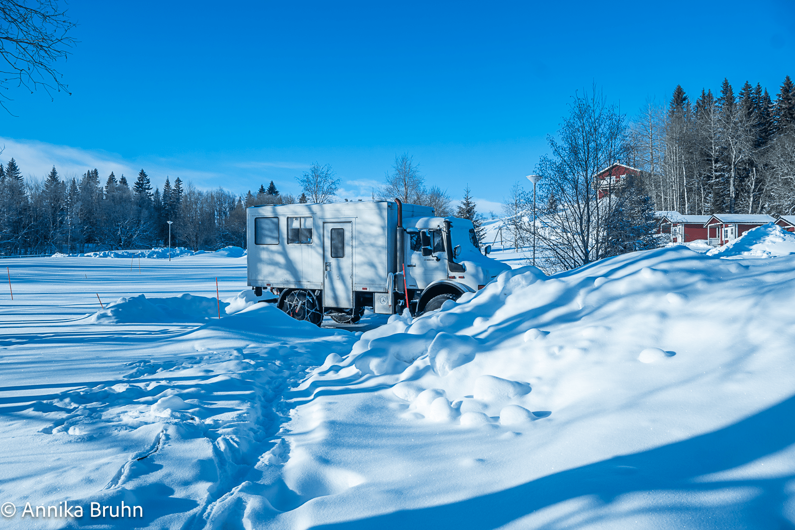 Karl versteckt sich hinter einem Schneehaufen